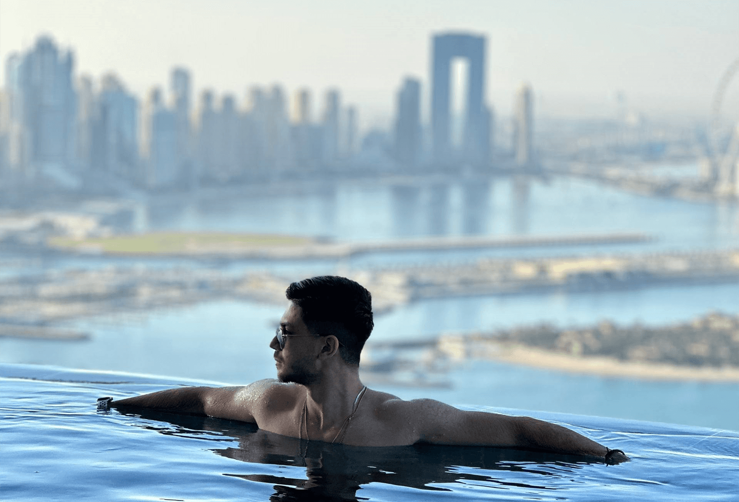 Farhad Bigonahi at an infinity pool overlooking the Dubai skyline