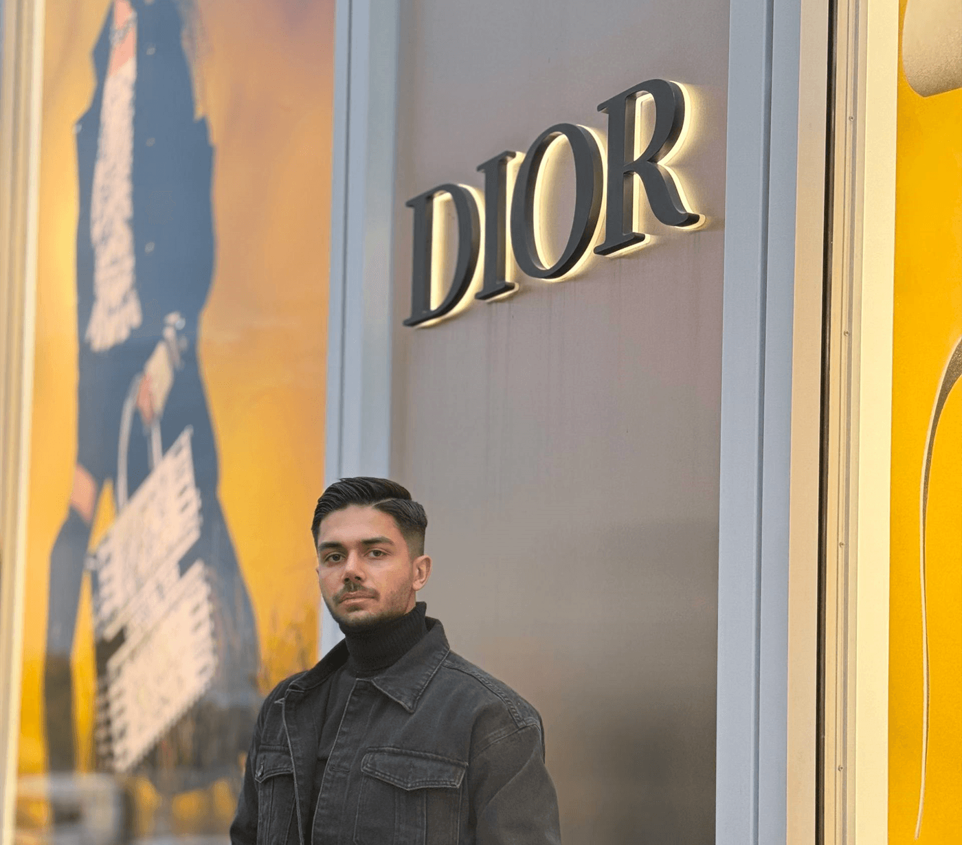 Farhad Bigonahi standing in front of an illuminated DIOR storefront